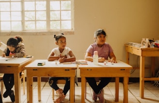 a group of children sitting at desks in a room