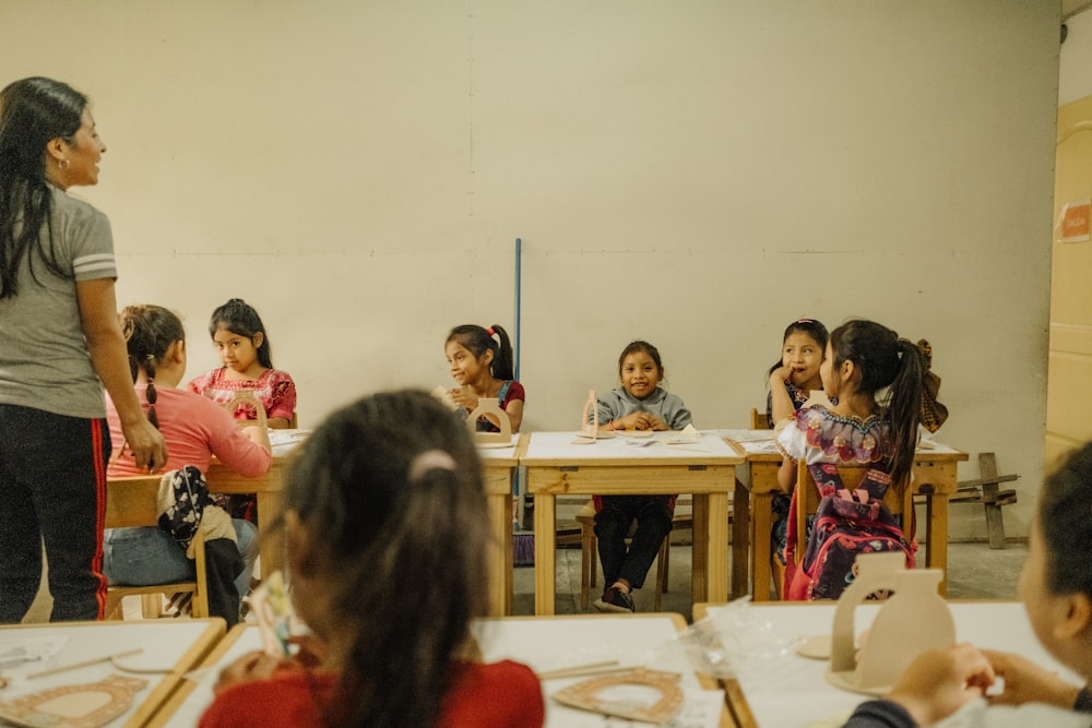 Un grupo de niños sentados en pupitres en un aula