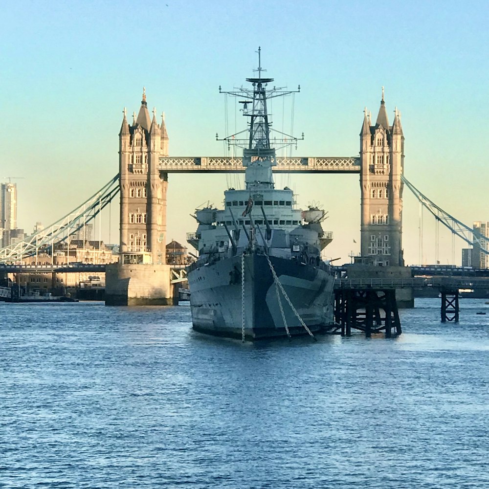 a large boat in the water near a bridge