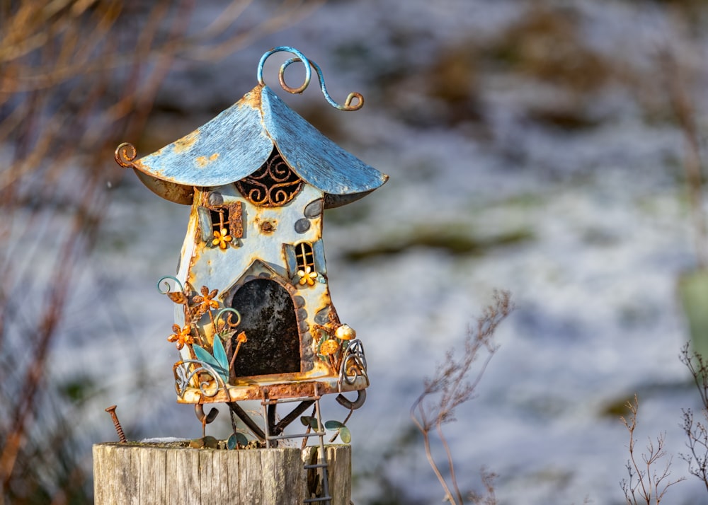 a bird house sitting on top of a wooden post