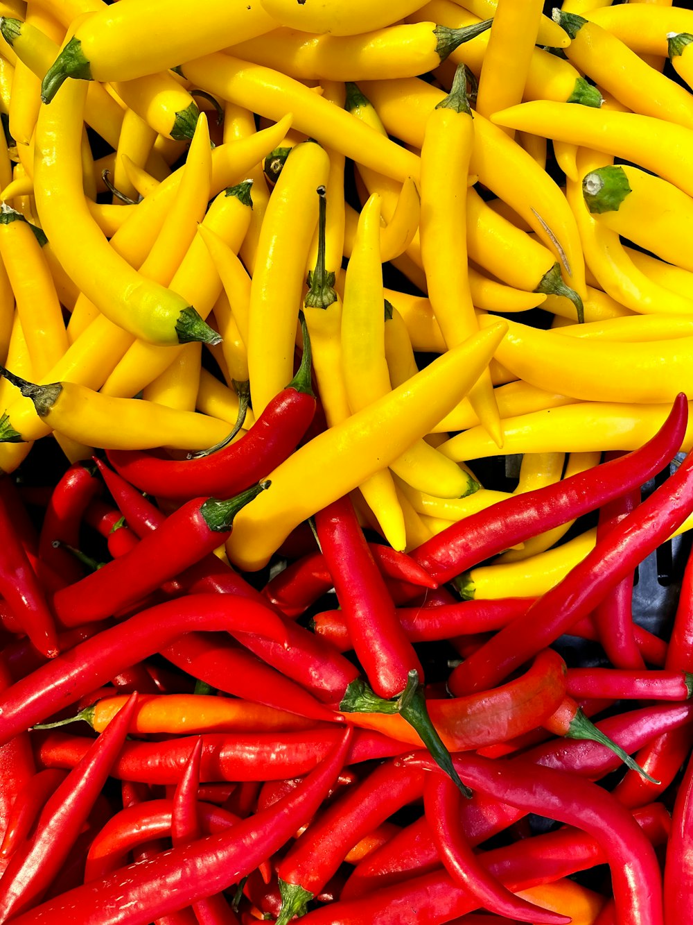 a pile of yellow and red peppers