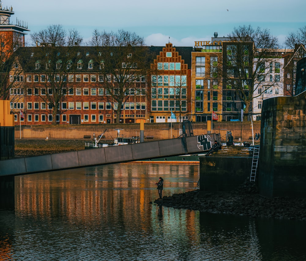 a man standing on a bridge over a body of water