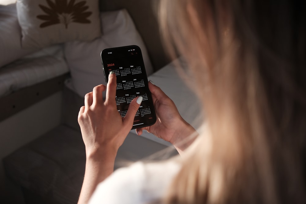 una mujer sosteniendo un teléfono celular frente a su cara