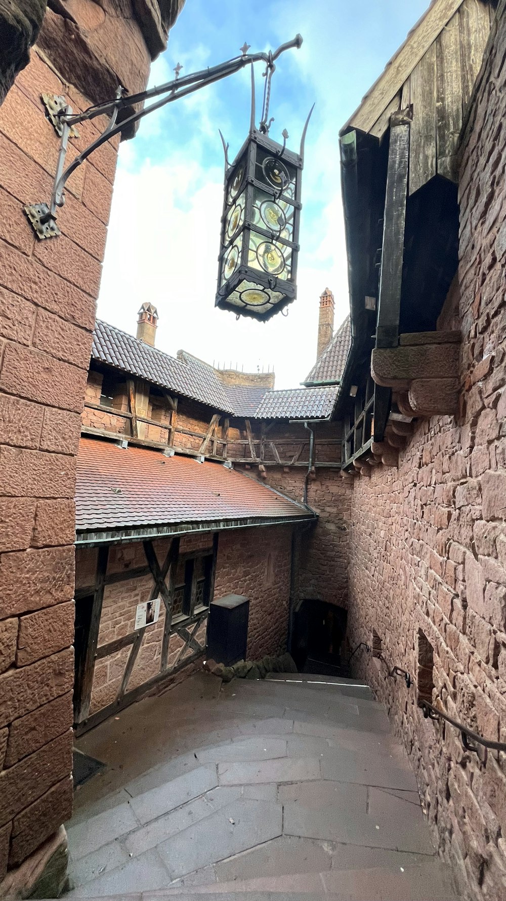 a clock hanging from the side of a brick building