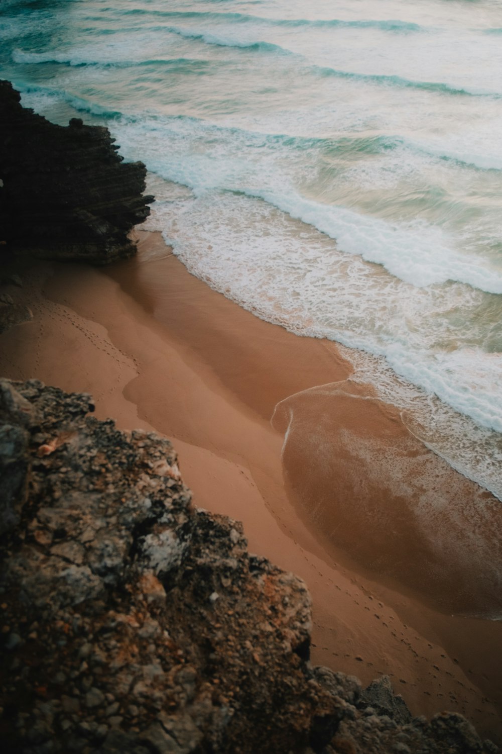 a sandy beach with waves coming in to shore