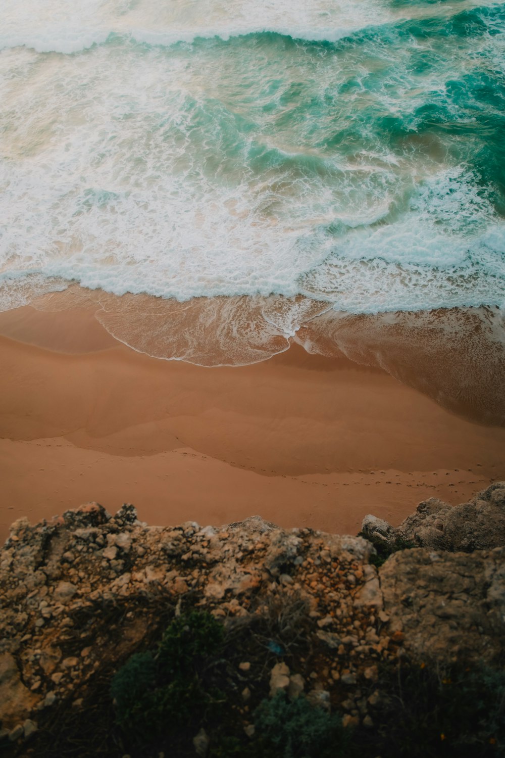 a sandy beach with waves coming in to shore