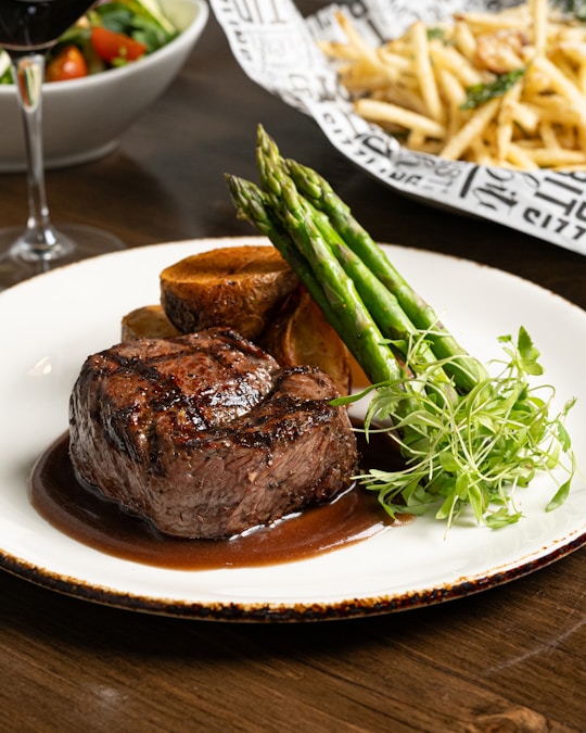 Elegantly plated filet mignon with asparagus and rich pan sauce at an upscale steakhouse