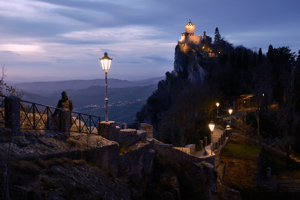 a person standing on a bridge looking at a castle