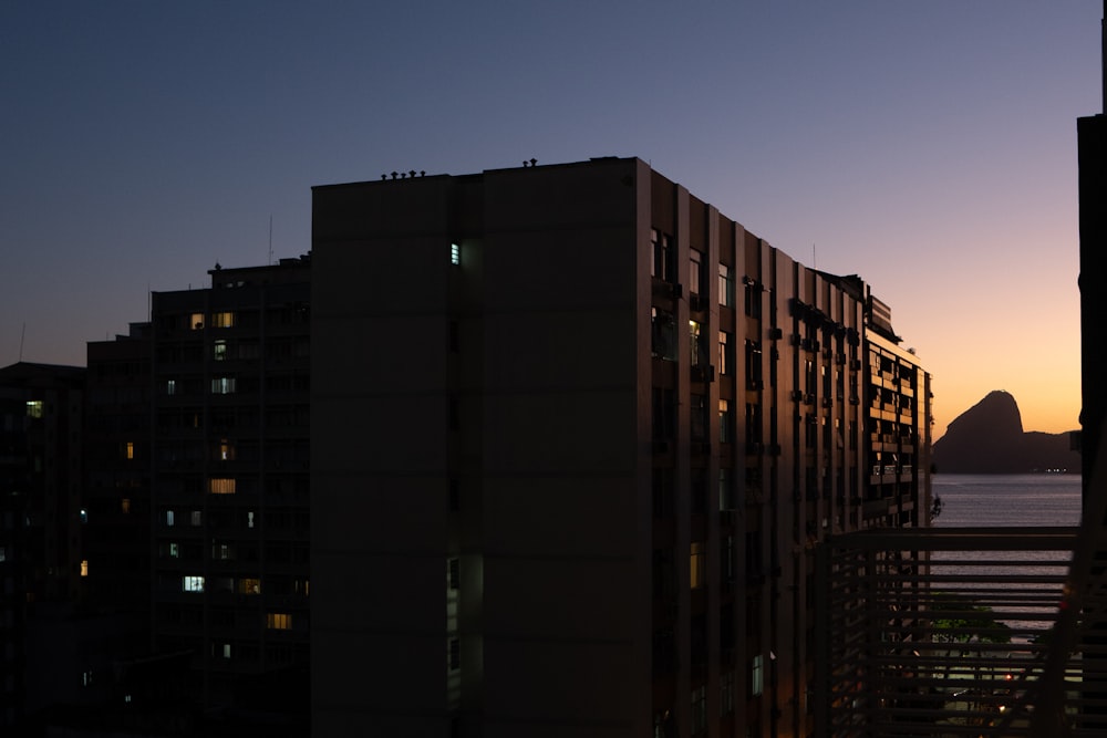 a sunset view of a city with a mountain in the background