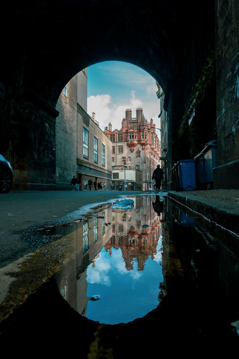 a reflection of a building in a puddle of water