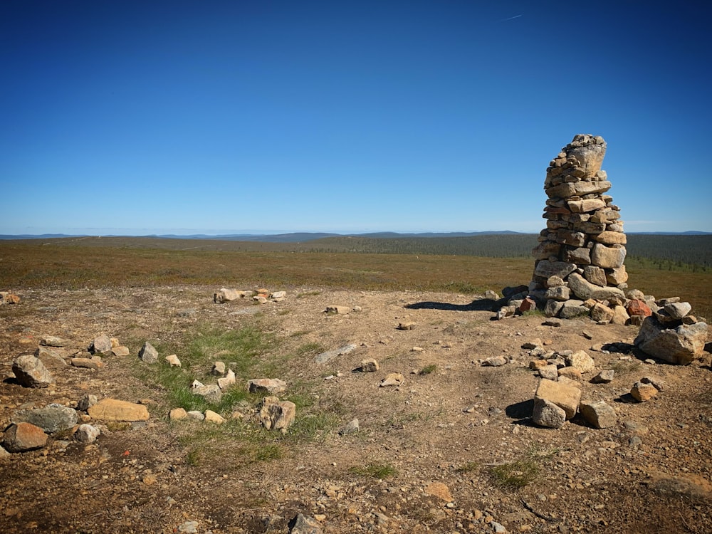 a pile of rocks sitting on top of a dry grass field