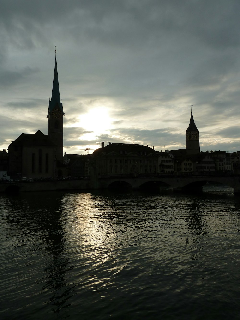 a river with a bridge and a church in the background