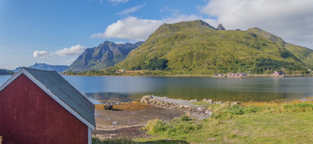 a small red building sitting next to a body of water