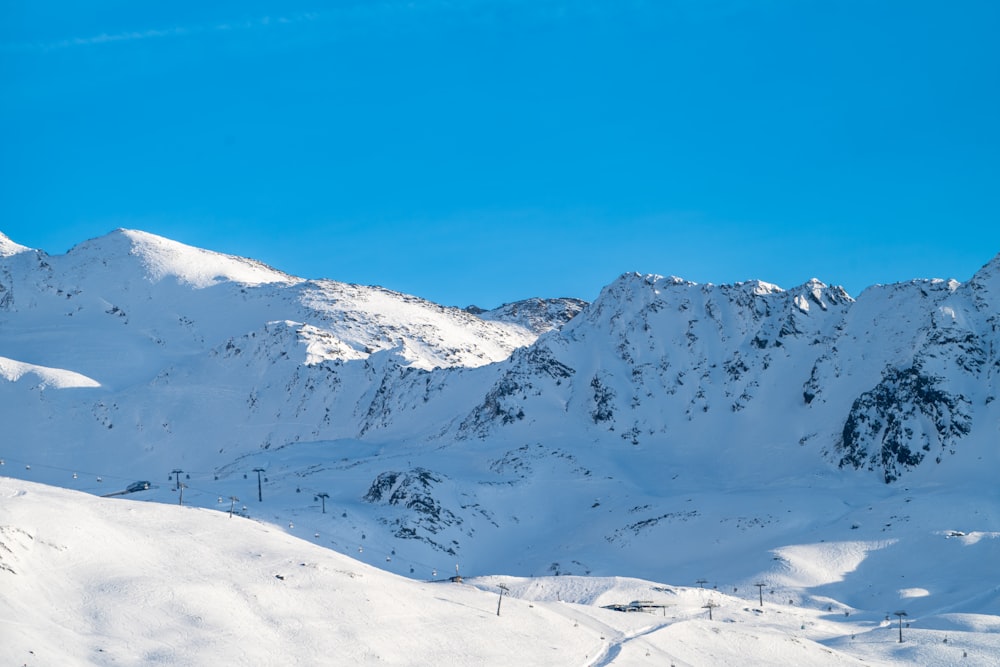 a snow covered mountain with a ski lift in the foreground