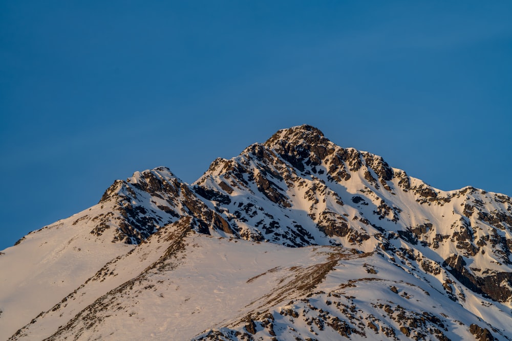 a mountain covered in snow under a blue sky