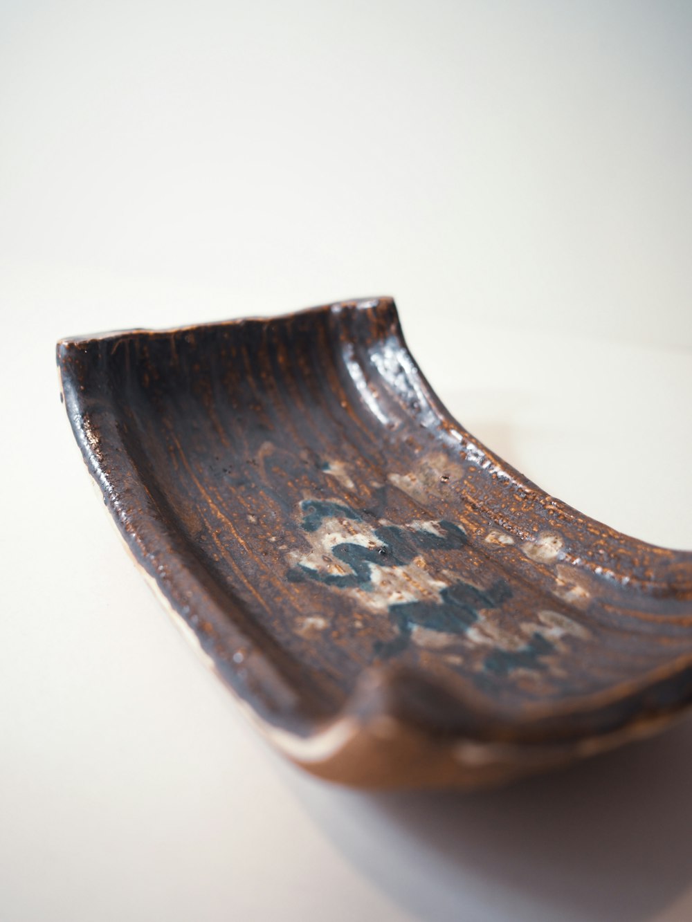 a wooden bowl sitting on top of a white table