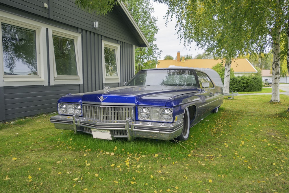 a blue car parked in front of a house