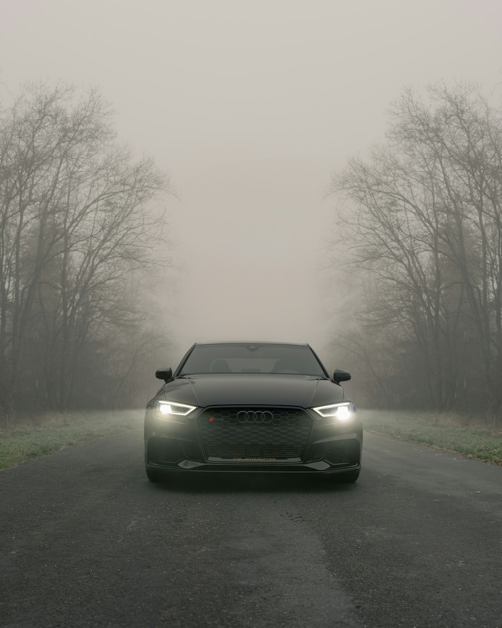 a car driving down a road in the fog