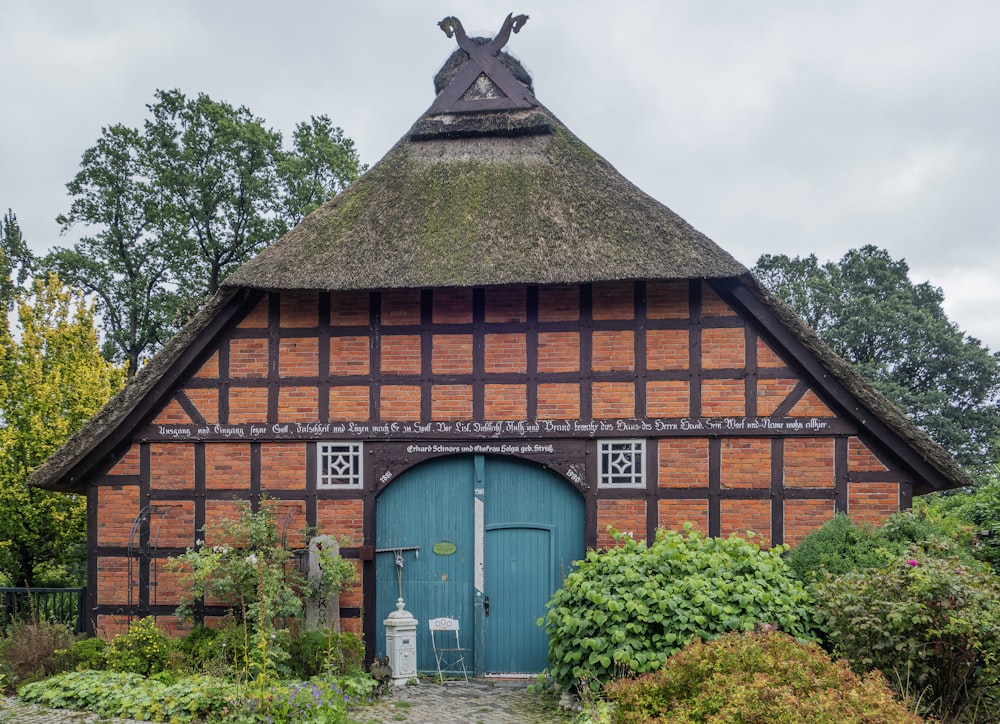 ein Gebäude mit Strohdach und blauer Tür