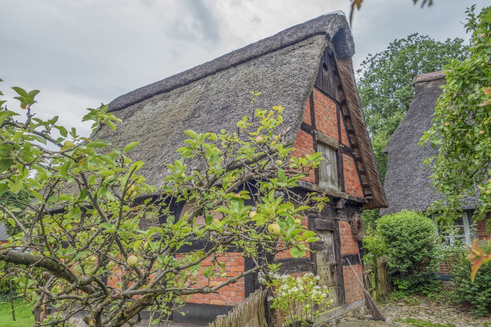 an old brick house with a thatched roof