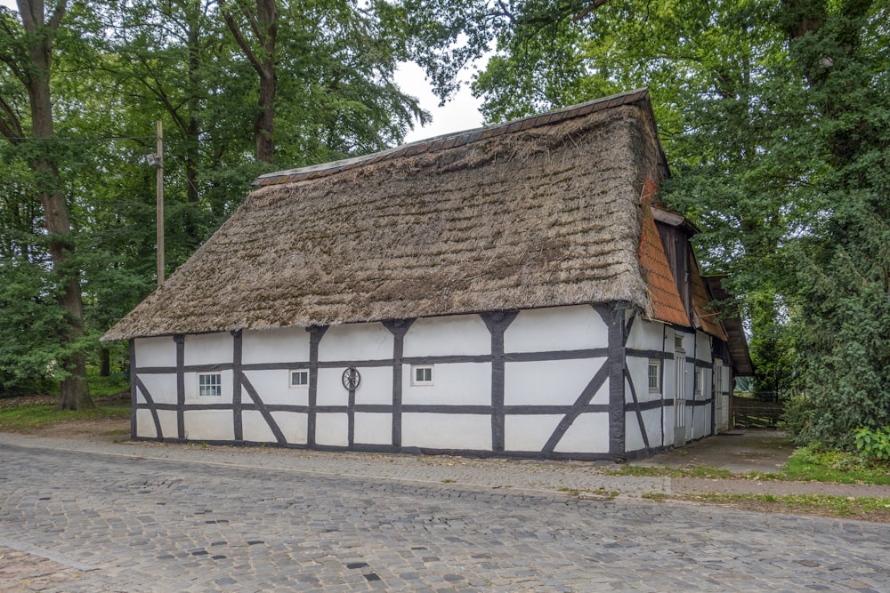 ein weiß-schwarzes Haus mit Strohdach