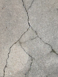 the crack in the concrete shows a crack in the road