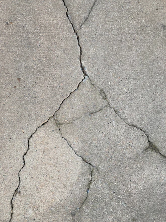 the crack in the concrete shows a crack in the road