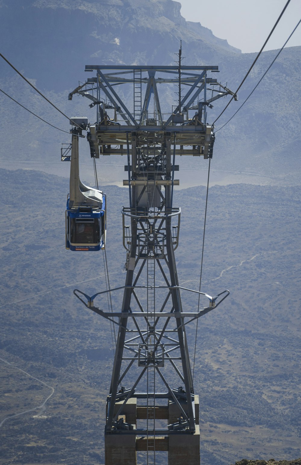 a cable car going up a mountain with a mountain in the background