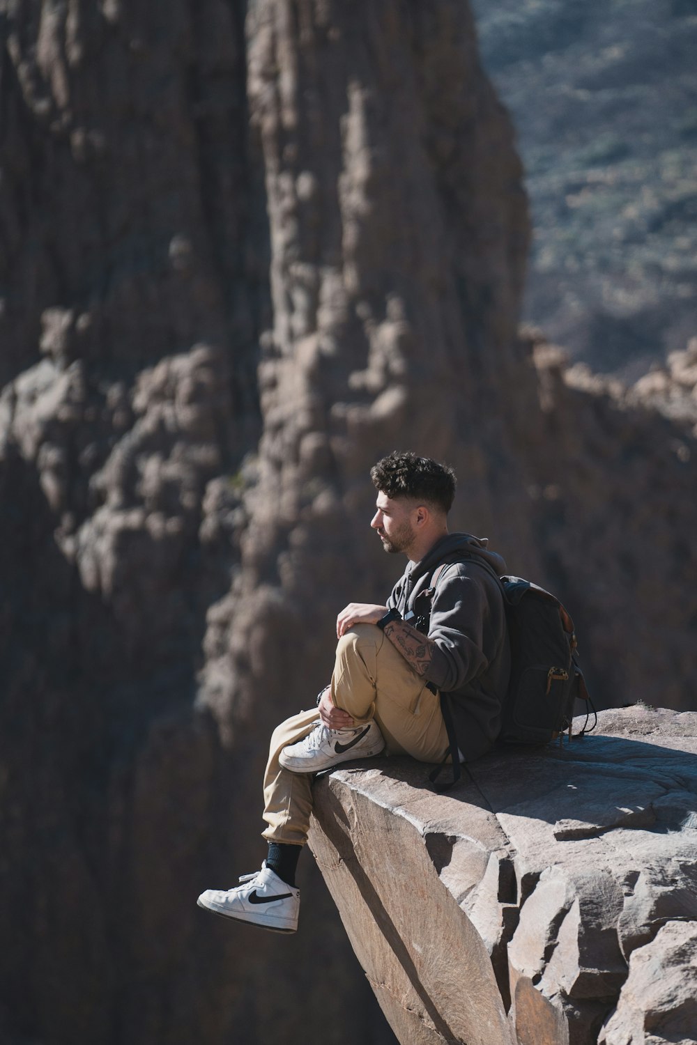 a man sitting on top of a rock next to a mountain
