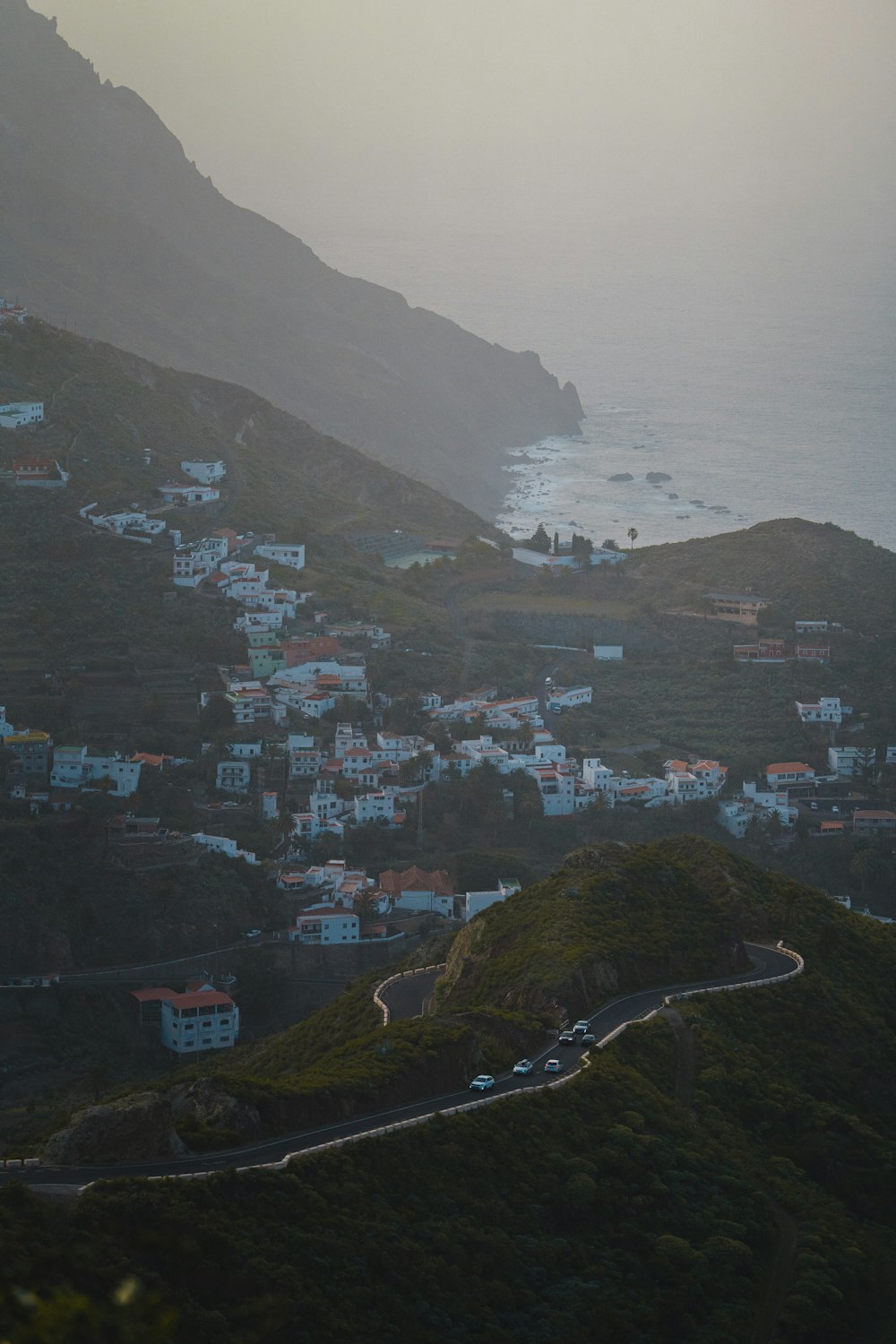 a scenic view of a town on a hill near the ocean