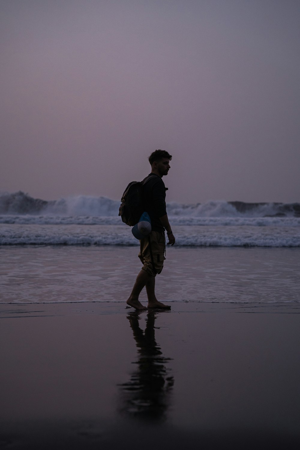Un hombre con una mochila caminando por la playa