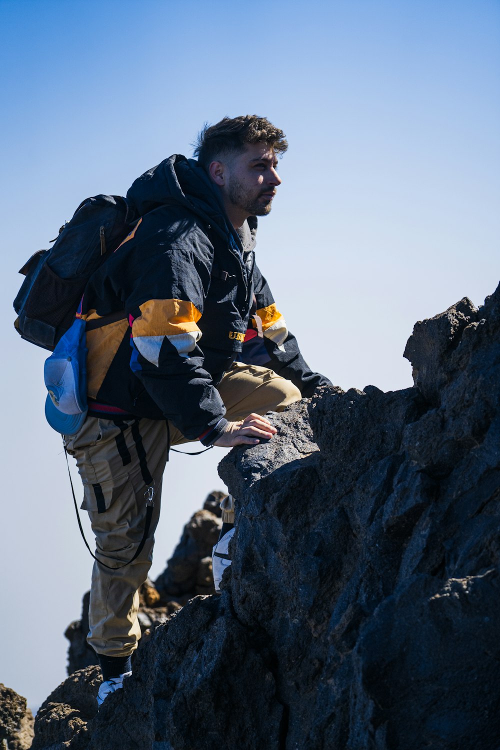 a man with a backpack climbing up a mountain