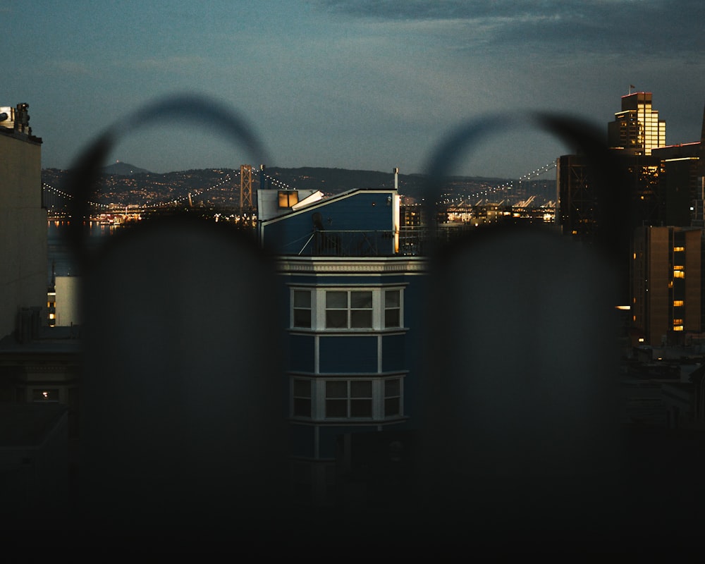 a view of a city from behind a fence