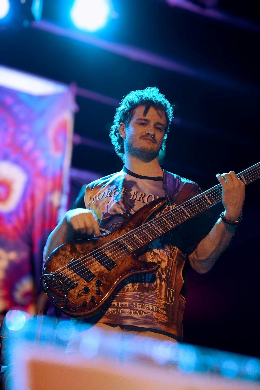 um homem tocando violão no palco em um concerto