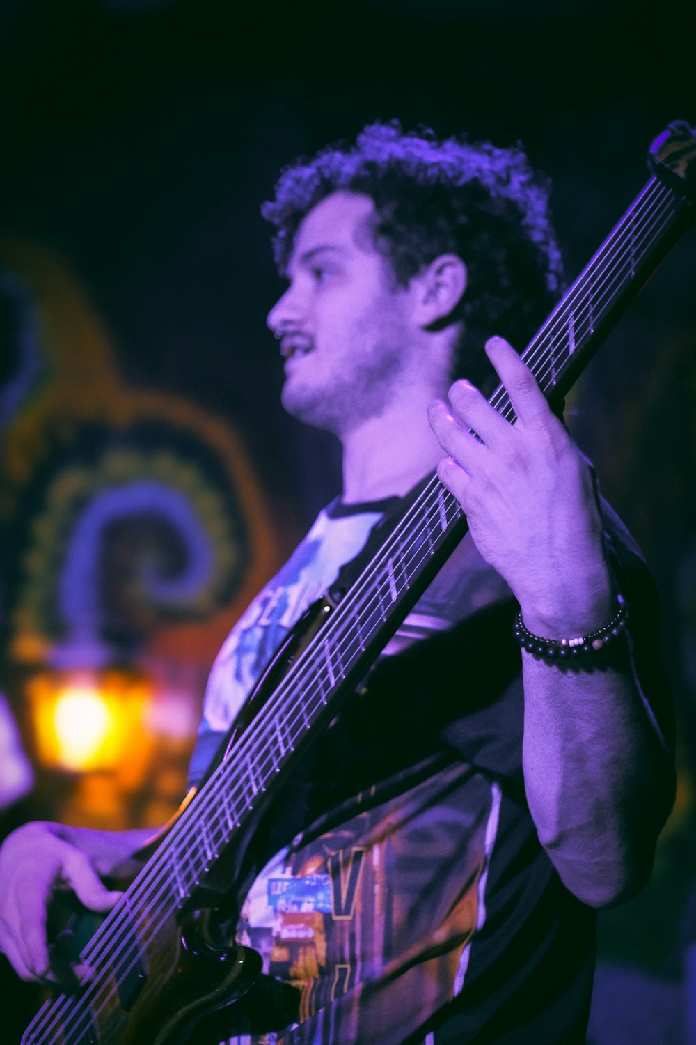 a man holding a guitar while standing in front of a microphone