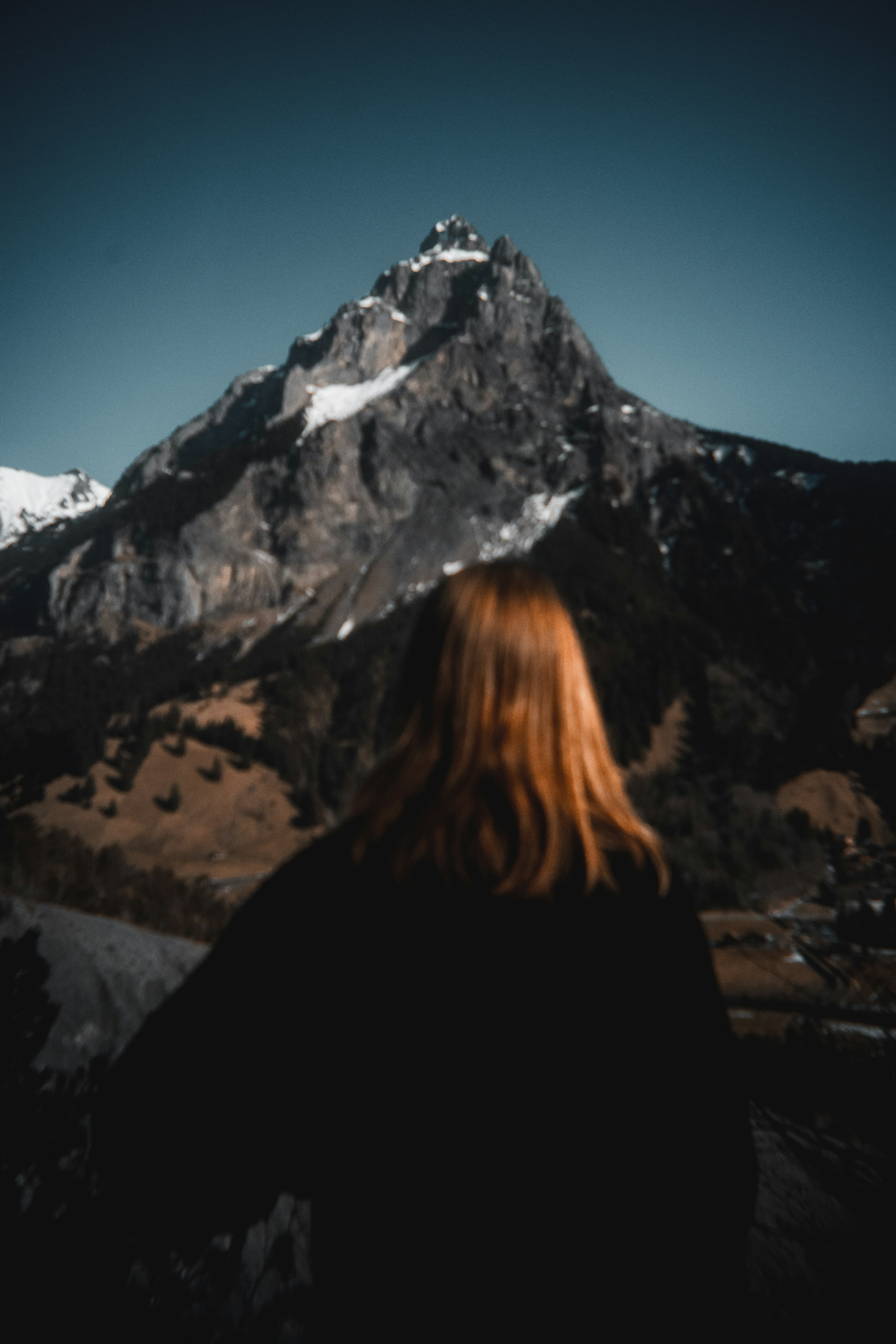 A woman with red hair standing in front of a mountain photo – Free ...
