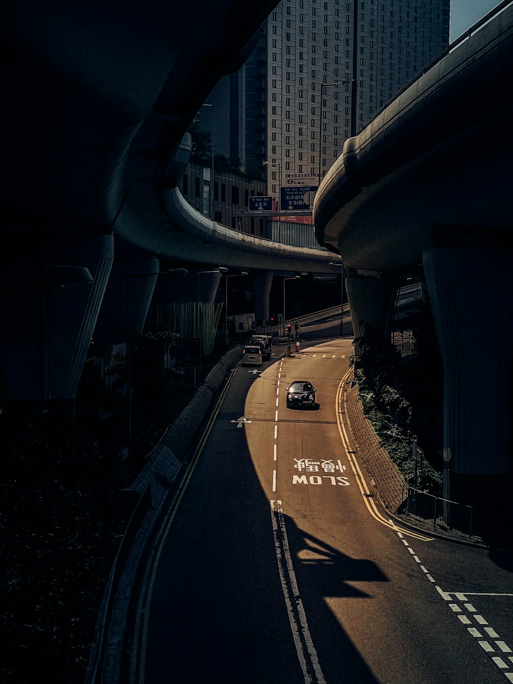 a car driving down a street next to tall buildings