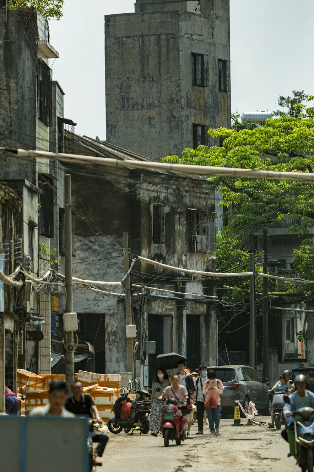 a group of people walking down a street next to tall buildings