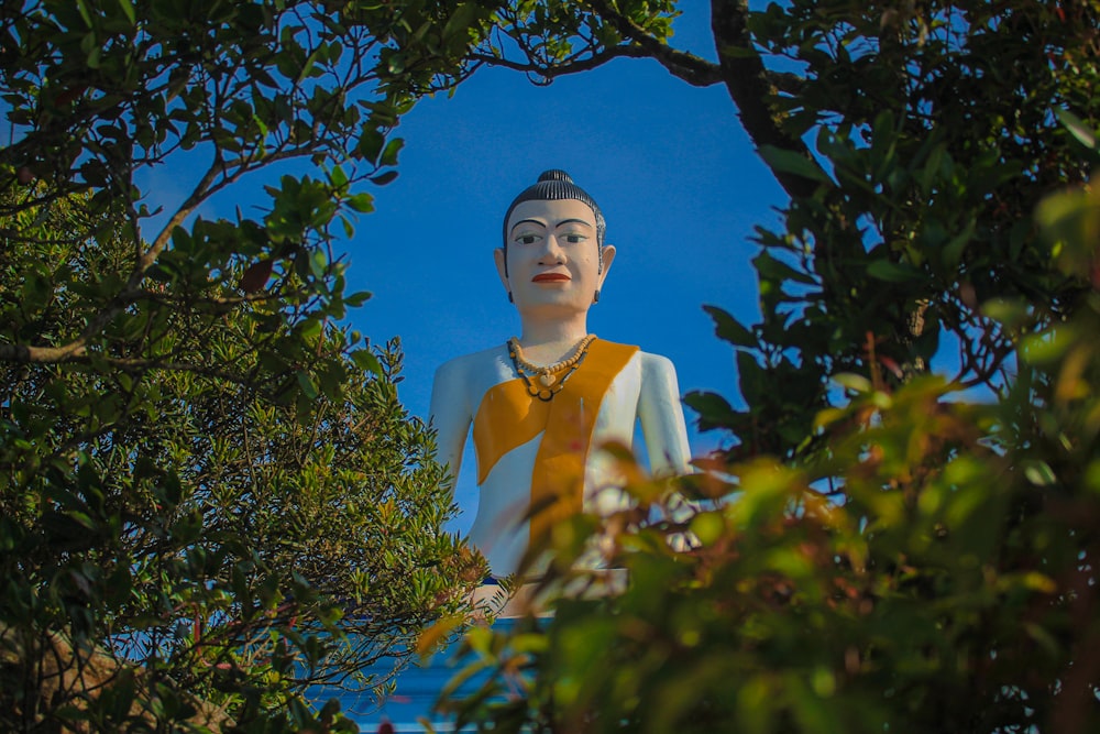 a buddha statue sitting in the middle of a forest