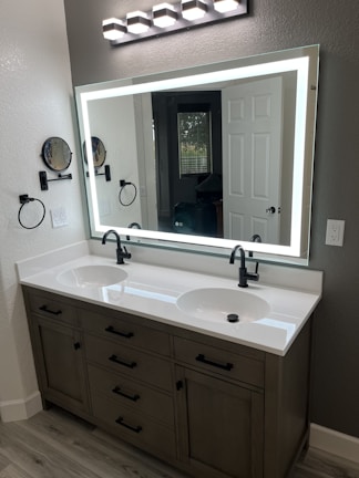 a bathroom with two sinks and a large mirror