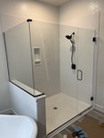 a bathroom with a glass shower door and a tub