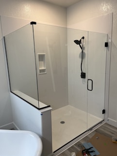 a bathroom with a glass shower door and a tub