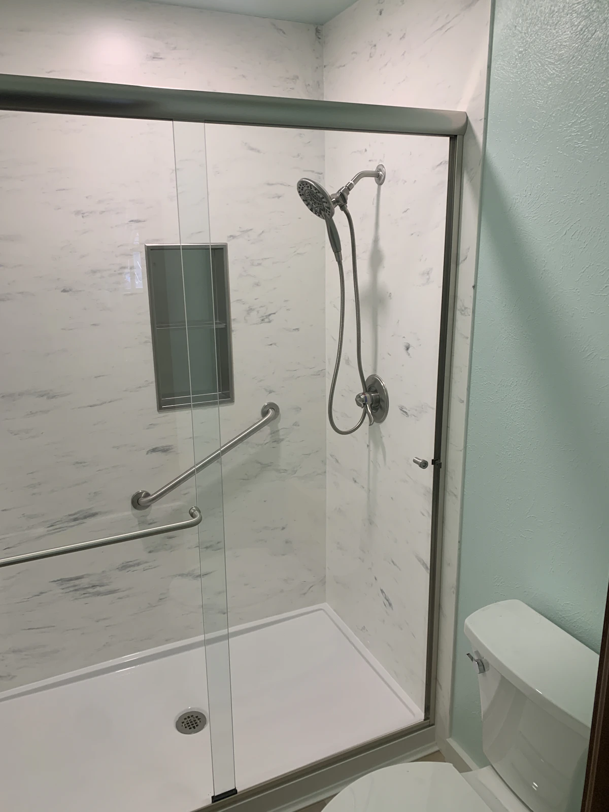 Bathroom shower and bathtub with fresh white caulking applied for a watertight seal
