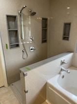 a bathroom with a sink, shower, and bathtub