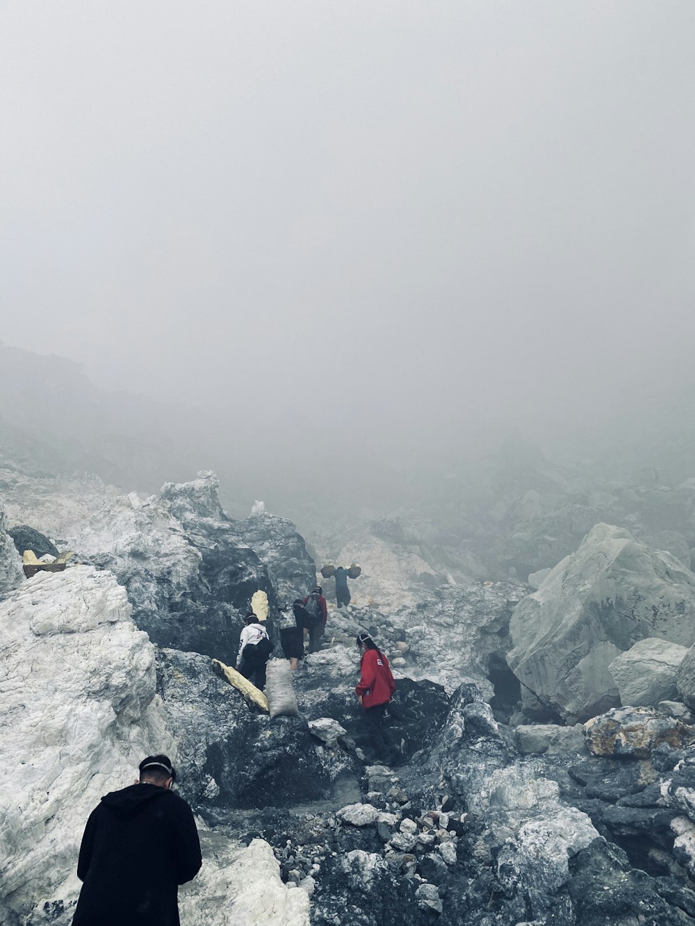 a group of people standing on top of a snow covered mountain