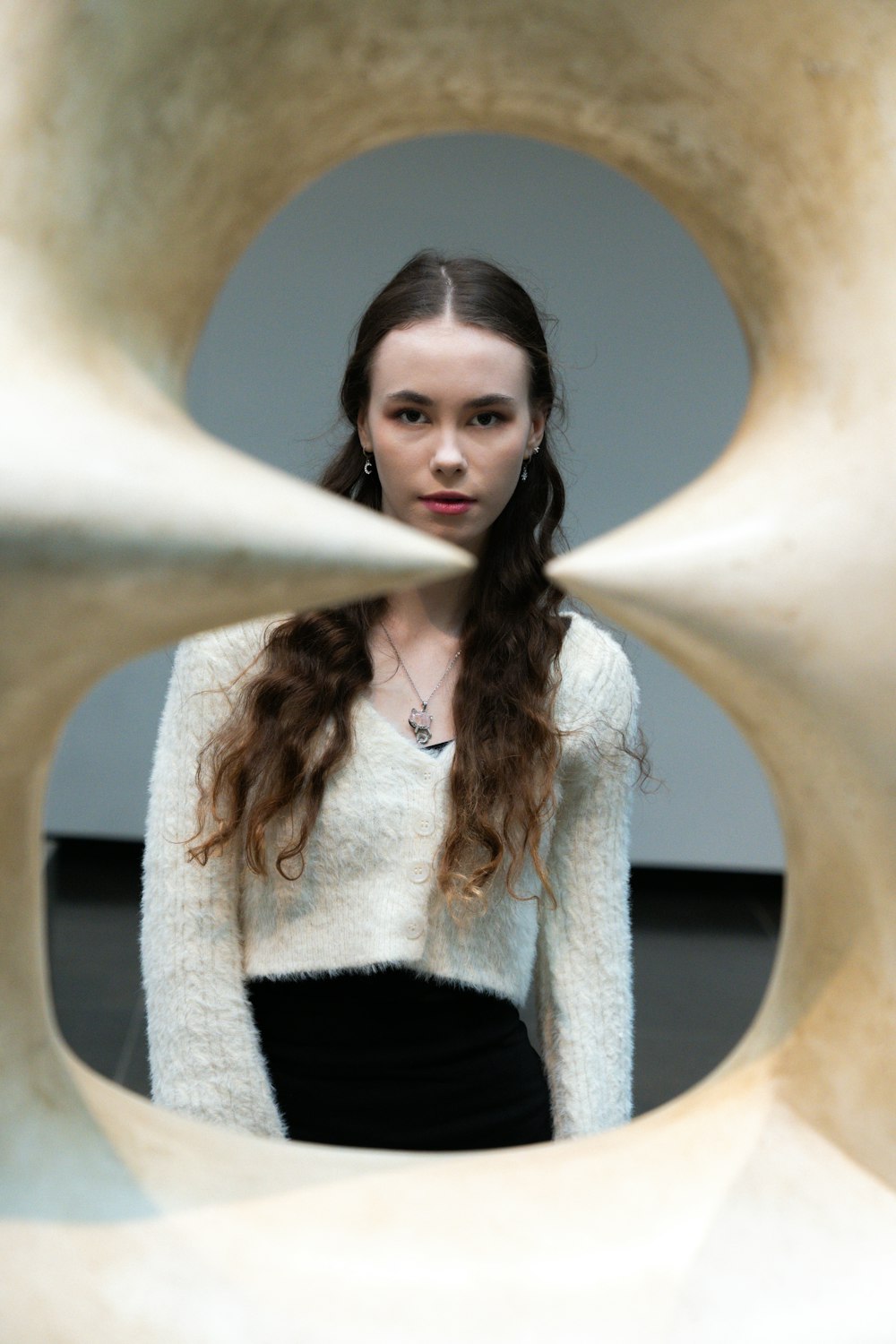 a woman standing in front of a sculpture