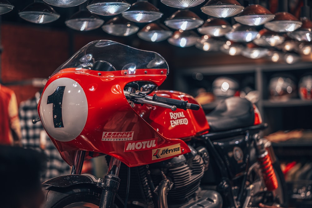 a red motorcycle parked inside of a garage