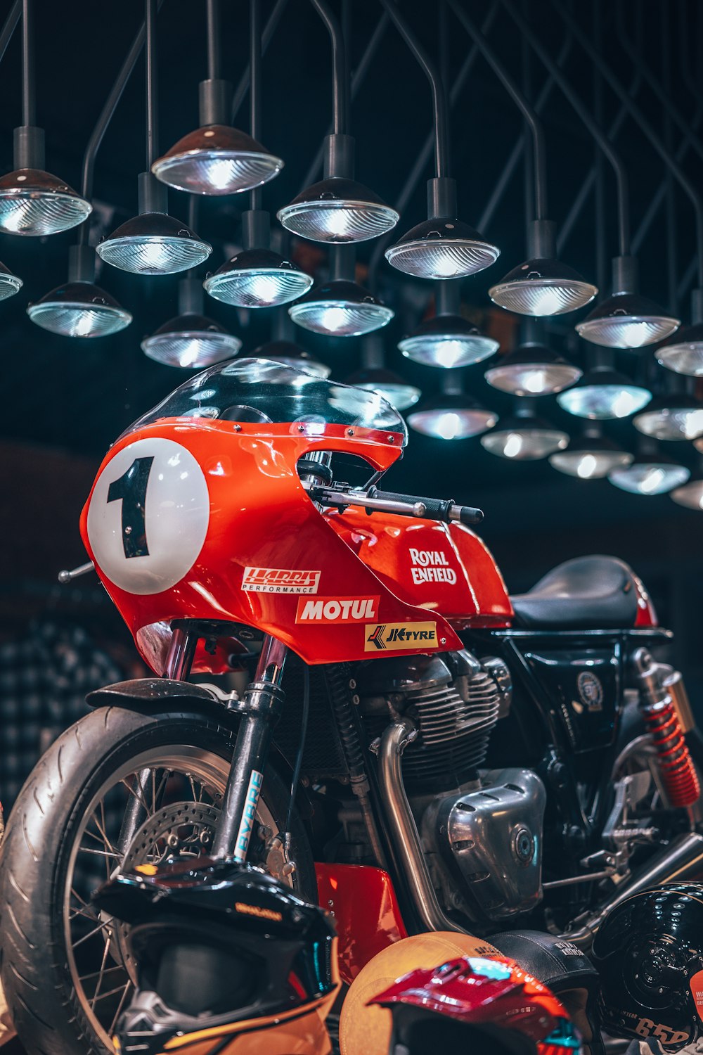 a red motorcycle parked in front of a bunch of lights