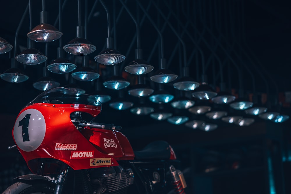 a red motorcycle parked under a bunch of lights