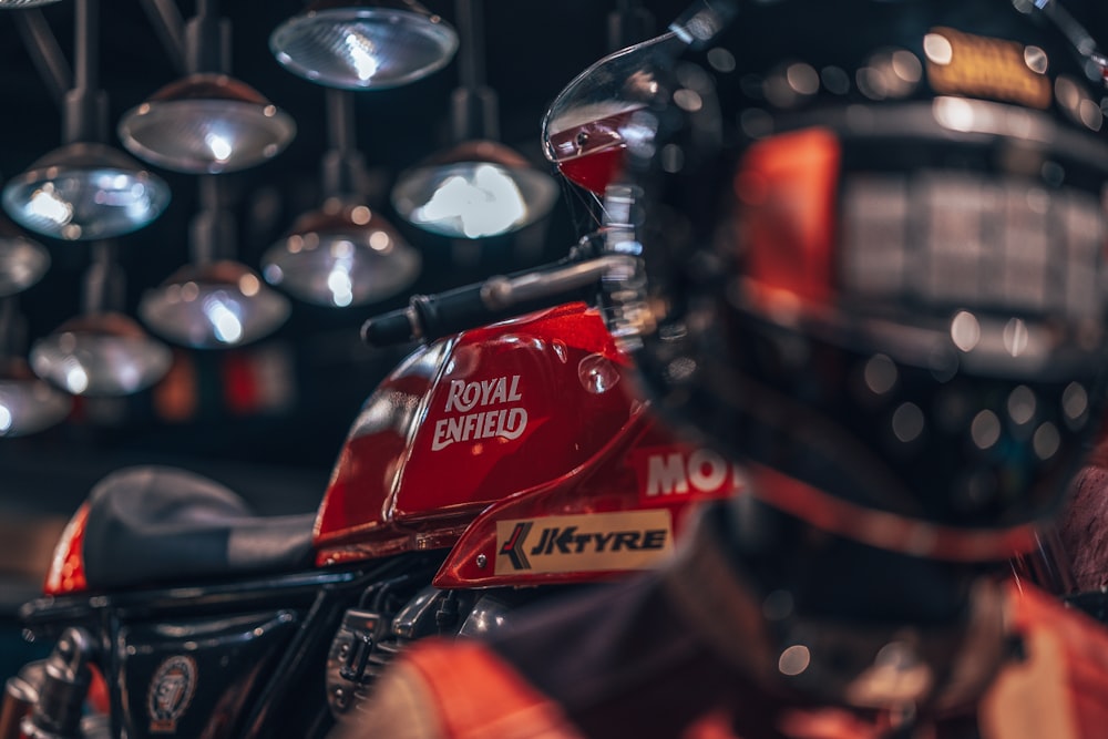 a close up of a red motorcycle parked in a garage